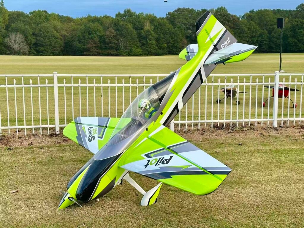 Pilot-RC aerobatic 3D airplane in green, black, and white on a grass field